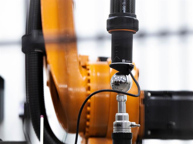 System ballbar RCS L-90 do automatyki przemysłowej firmy Renishaw zamontowany między ramieniem robota a kulą wzorcową w gnieździe produkcyjnym z robot